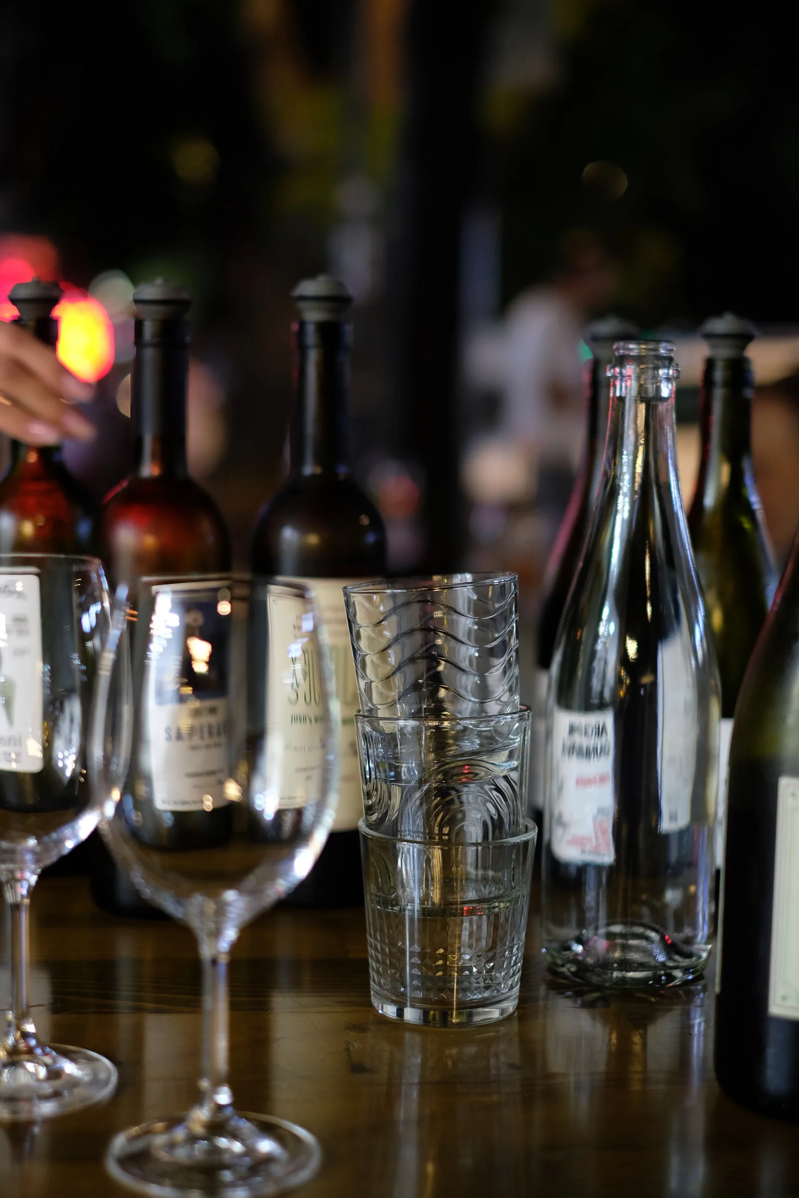 Wine bottles, empty glasses and stacked tumblers on the tasting table at MIDI.